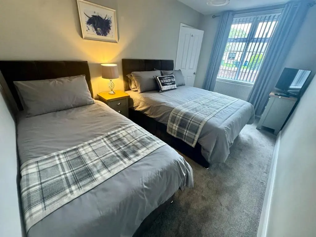 a bedroom with two beds and a window at City Centre 3 Bedroom house with parking in Dalneigh
