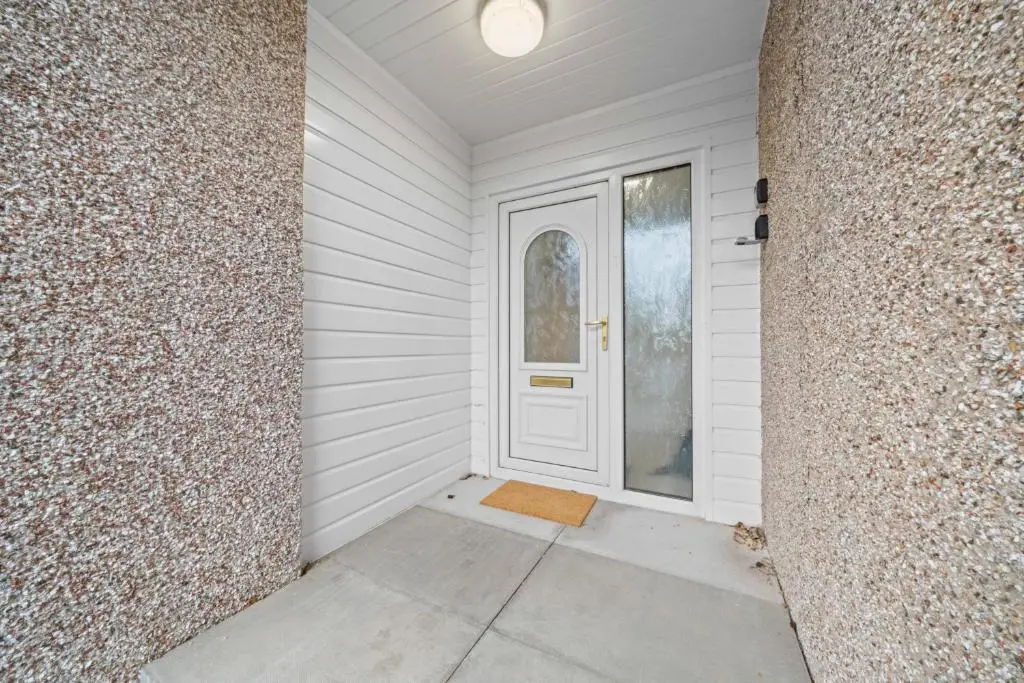 a white door on a house with a stone wall at Temple 1 Bedroom Studio - Inverness in Inverness