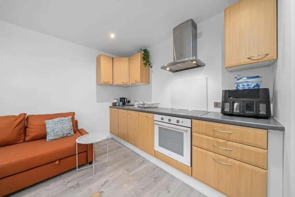 a kitchen with a couch and a microwave at Temple 1 Bedroom Studio - Inverness in Inverness