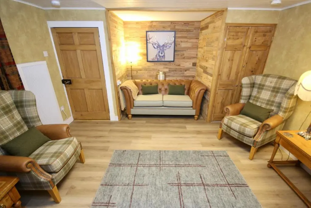a living room with two chairs and a couch at Serenity by the Sea in Buckie