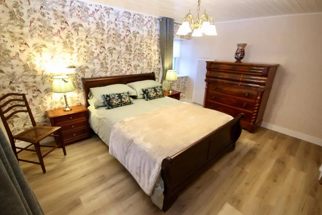 a bedroom with a bed and a dresser and a chair at Serenity by the Sea in Buckie
