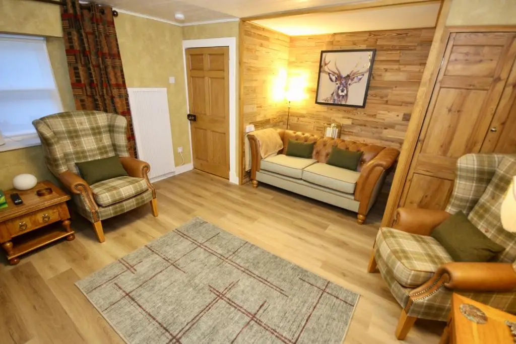 a living room with a couch and two chairs at Serenity by the Sea in Buckie