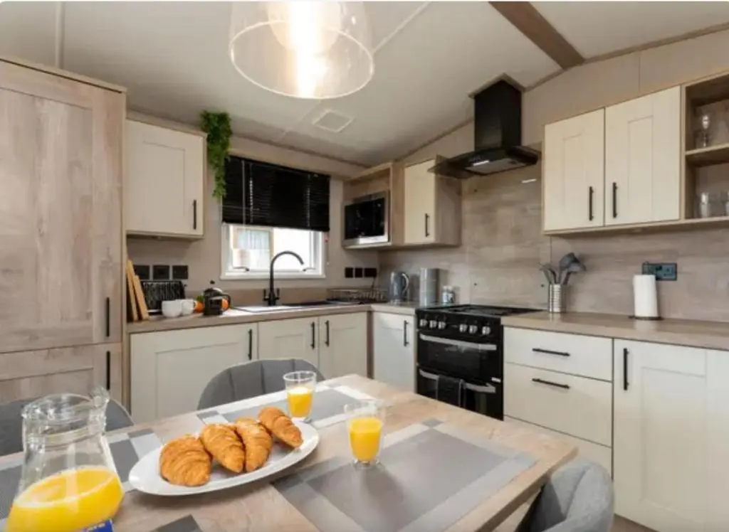 a kitchen with a table with bread and orange juice at ScottishHighlands in Boat of Garten