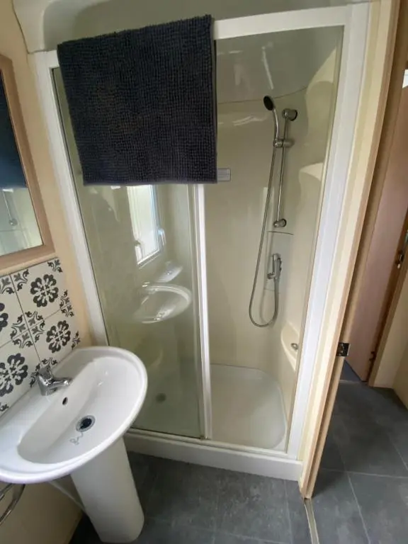 a bathroom with a shower and a sink at No 56 Headiton Caravan Park in Banff