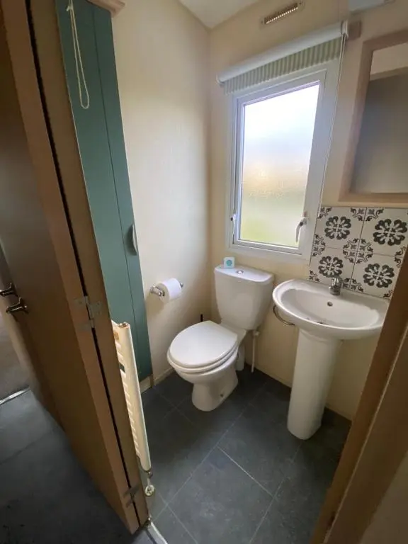 a bathroom with a toilet and a sink at No 56 Headiton Caravan Park in Banff