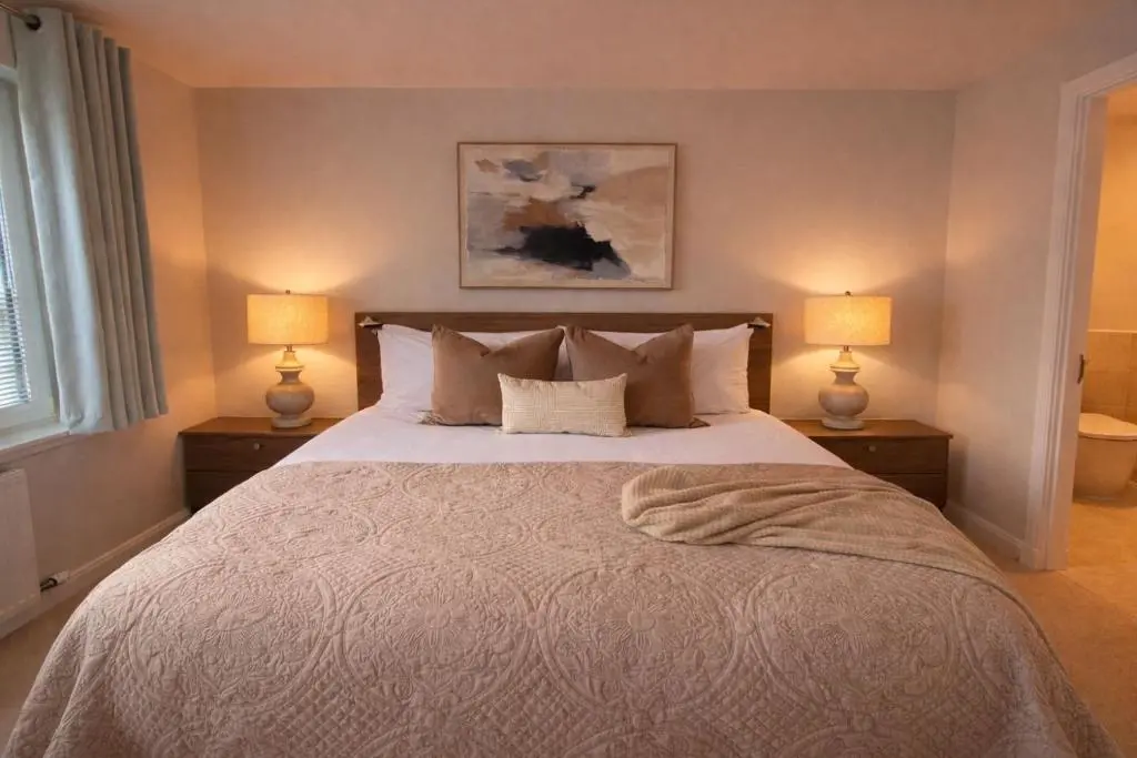 a bedroom with a large bed with two lamps at Ness Garden in Inverness