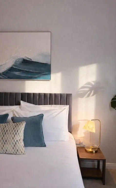 a bedroom with a bed and a table with a lamp at Ness Garden in Inverness