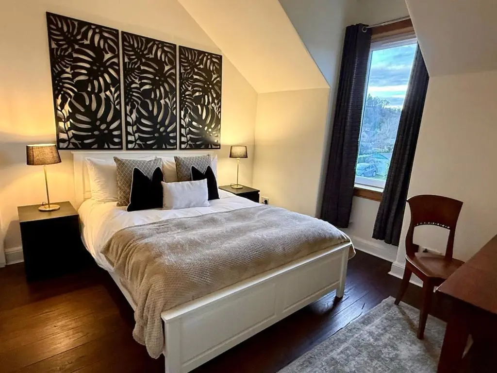 a bedroom with a large bed and a window at The Yellow Door in Inverness