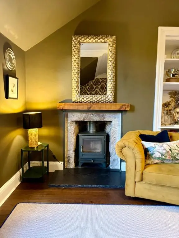 a living room with a fireplace and a mirror at The Yellow Door in Inverness