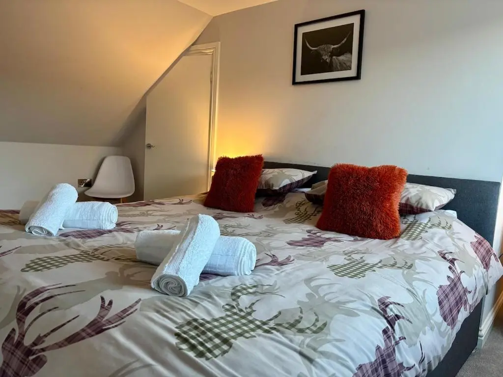 a bedroom with a bed with pillows on it at Cosy cottage in idyllic Speyside setting in Rothes
