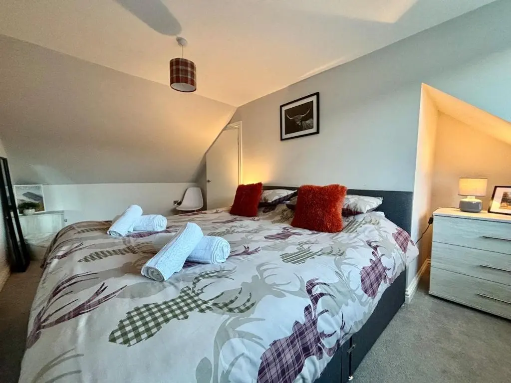 a bedroom with a bed with pillows on it at Cosy cottage in idyllic Speyside setting in Rothes