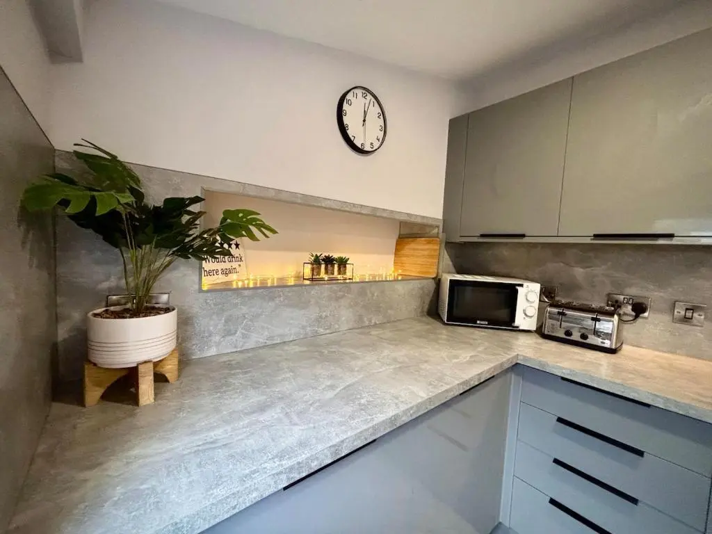 a kitchen with a microwave and a clock on the wall at Stunning Speyside retreat, ideal for Whisky lovers in Rothes