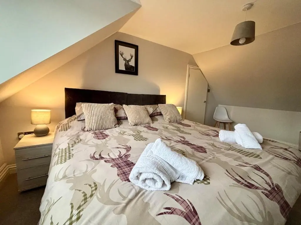 a bedroom with a large bed with two pillows on it at Stunning Speyside retreat, ideal for Whisky lovers in Rothes