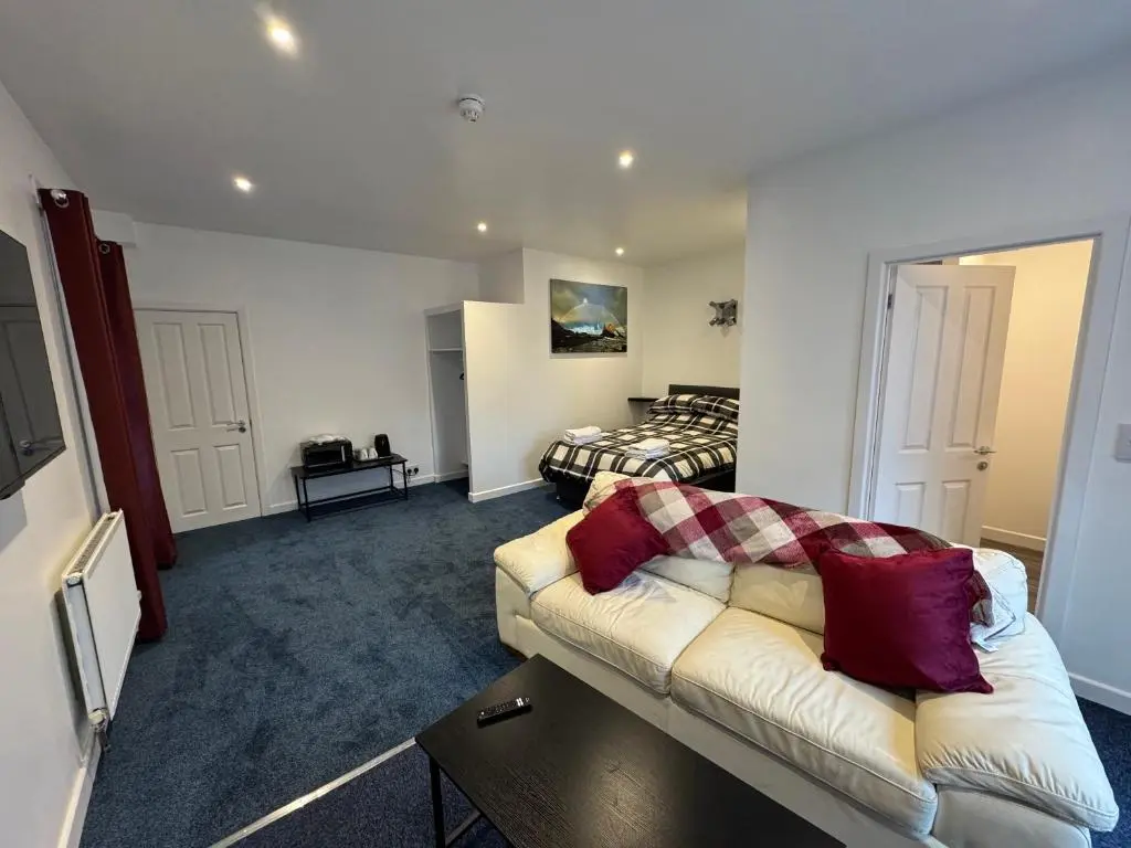 a living room with a couch and a bed at Grant Arms Hotel in Cullen