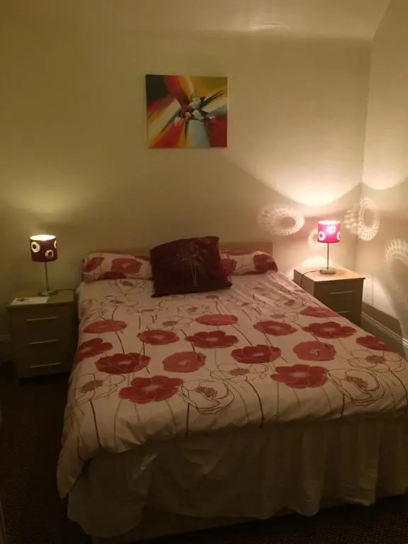 a bedroom with a bed with a red and white blanket at Grant Arms Hotel in Cullen