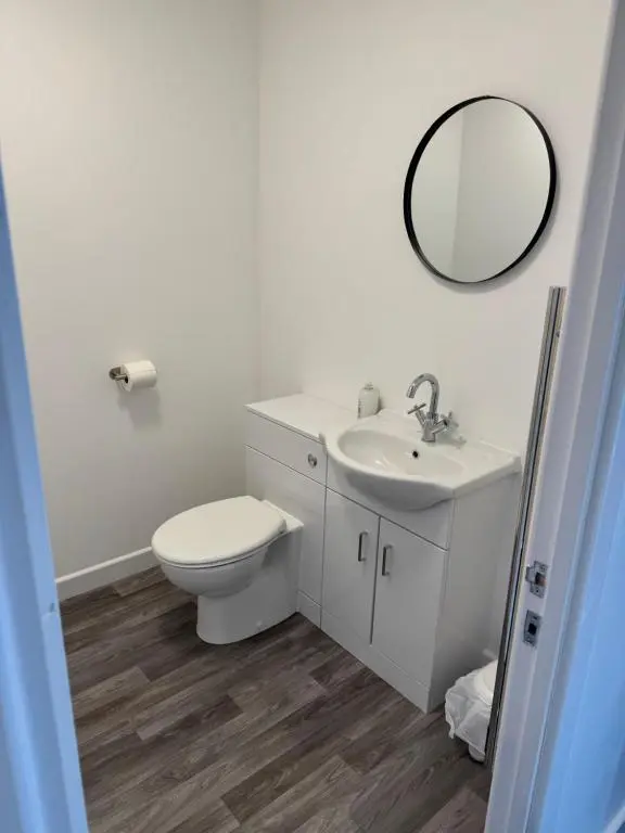 a bathroom with a toilet and a sink and a mirror at Grant Arms Hotel in Cullen