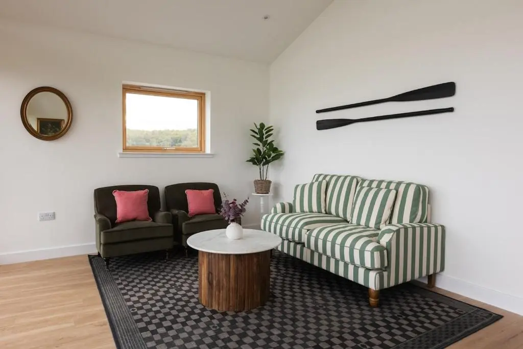 a living room with two chairs and a table at Luxury Farmhouse, near Dornoch