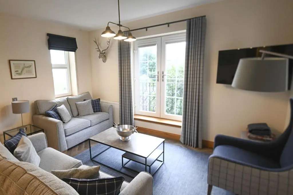 a living room with a couch and a table at Royal Gardens Apartment 5 in Dornoch
