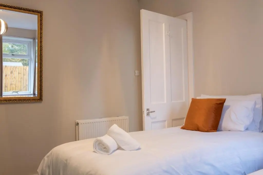 a bedroom with a bed with two pillows on it at Roos Cottage in Ellon