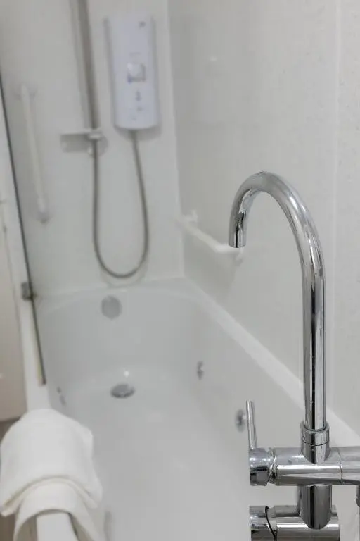 a bathroom with a shower and a sink with a faucet at Roos Cottage in Ellon