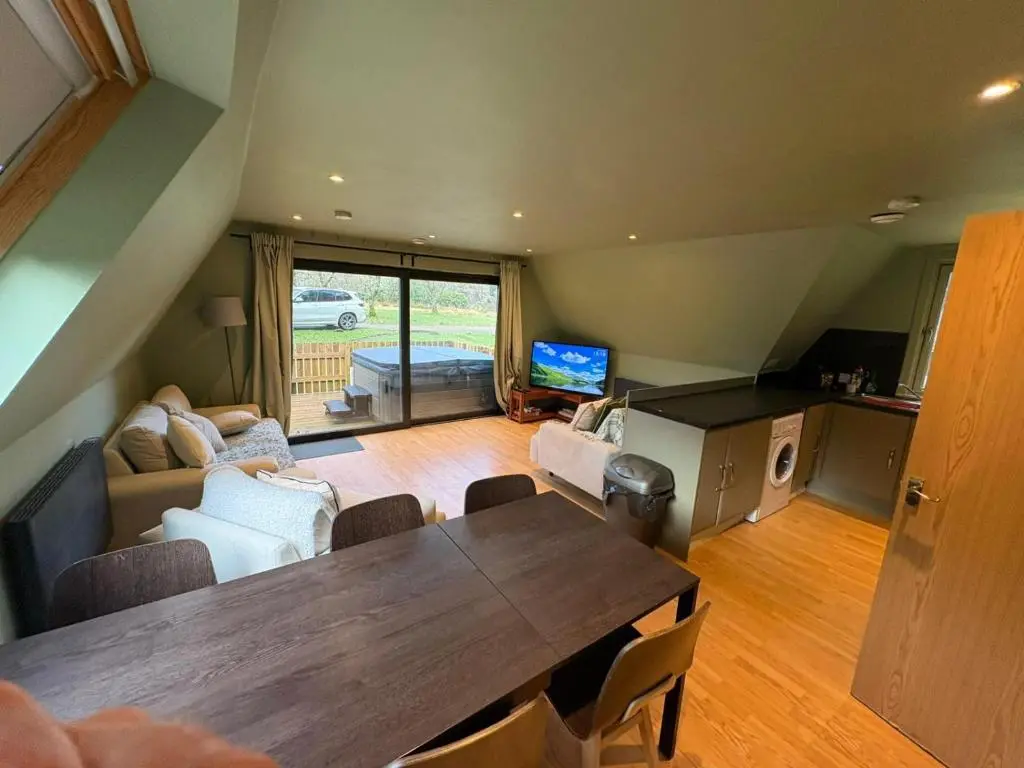 a living room with a wooden table and a couch at The Great Glen Getaway Lodge in Spean Bridge