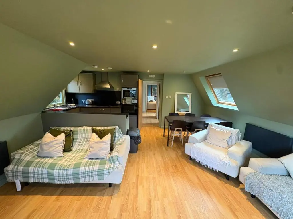 a living room with two couches and a kitchen at The Great Glen Getaway Lodge in Spean Bridge