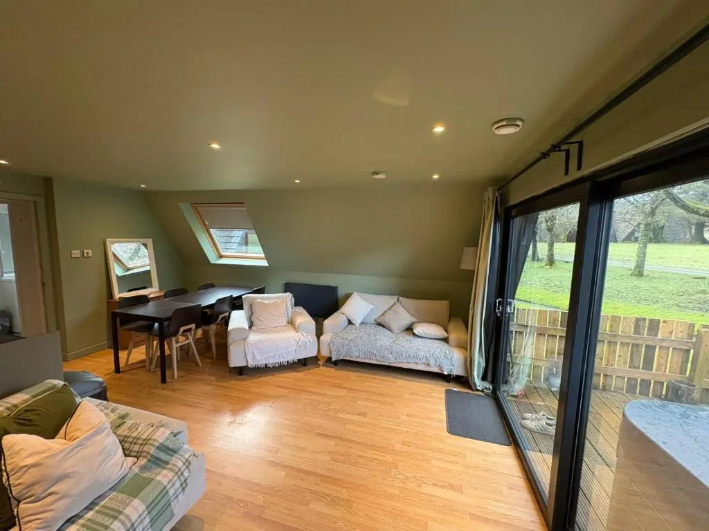 a living room with a couch and a dining room at The Great Glen Getaway Lodge in Spean Bridge