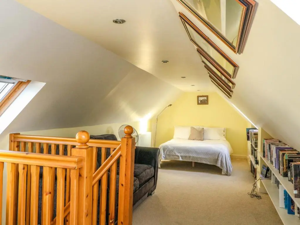 a attic bedroom with a bed and a book shelf at 78 Findhorn in Forres