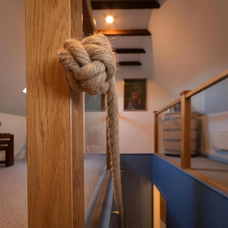 a rope tied to a wooden door in a room at Sea Crest - Beachfront Escape with Whisky Snug in Cullen