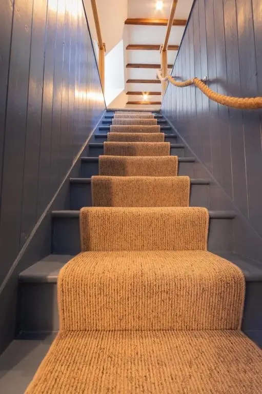 a set of stairs with a rug on them at Sea Crest - Beachfront Escape with Whisky Snug in Cullen