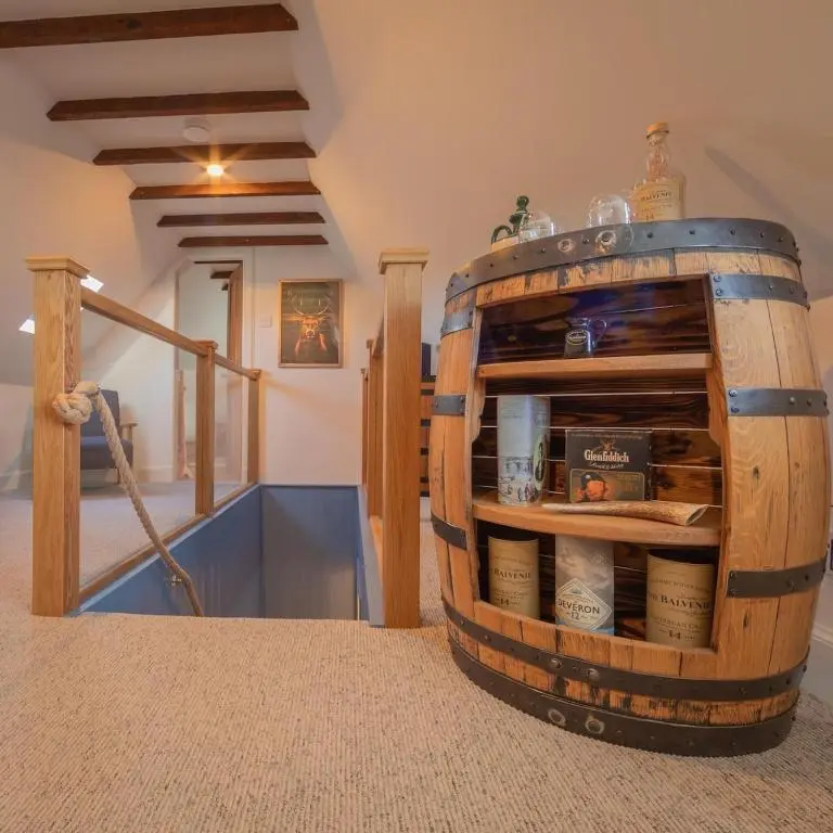 a large wooden barrel sitting in a room at Sea Crest - Beachfront Escape with Whisky Snug in Cullen