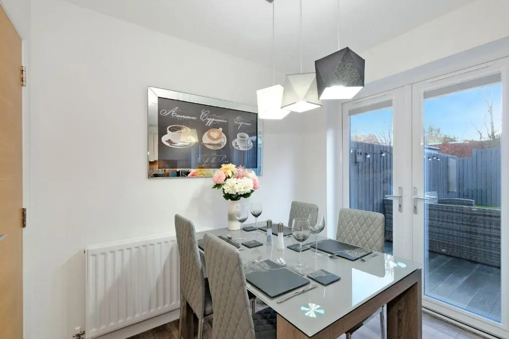 a dining room with a table and chairs and a window at A comfortable and modern 2BR 2BA home near ABZ in Inverurie