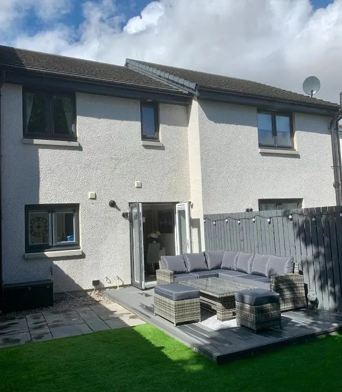 a patio with a couch and a fence in front of a house at A comfortable and modern 2BR 2BA home near ABZ in Inverurie