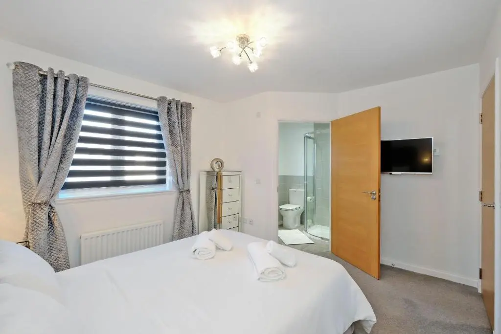 a bedroom with a white bed and a window at A comfortable and modern 2BR 2BA home near ABZ in Inverurie