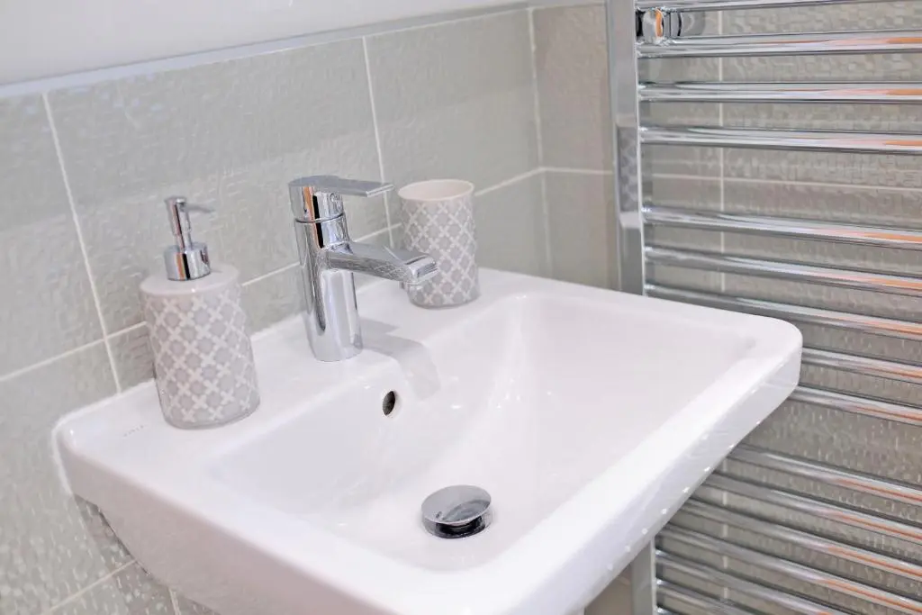 a white bathroom sink with two cups on it at A comfortable and modern 2BR 2BA home near ABZ in Inverurie