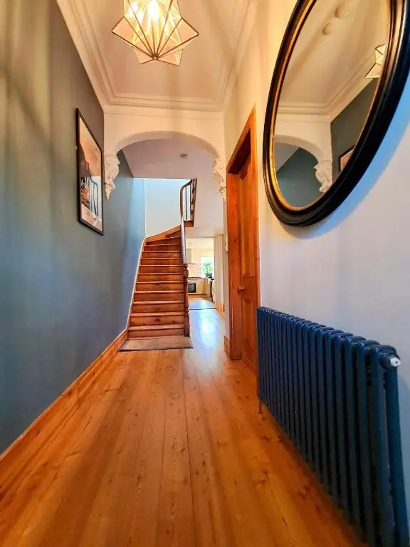 a hallway with a mirror and stairs in a house at 42 in the Crown in Inverness