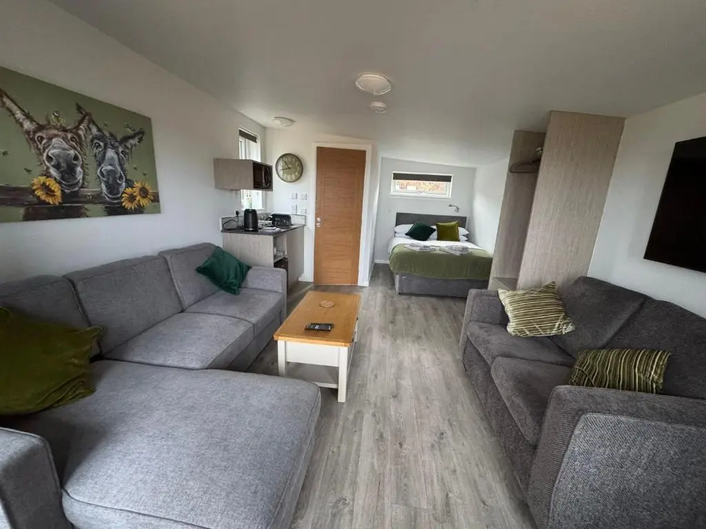 a living room with two couches and a bed at Inverness Ardtower Escapes in Culloden