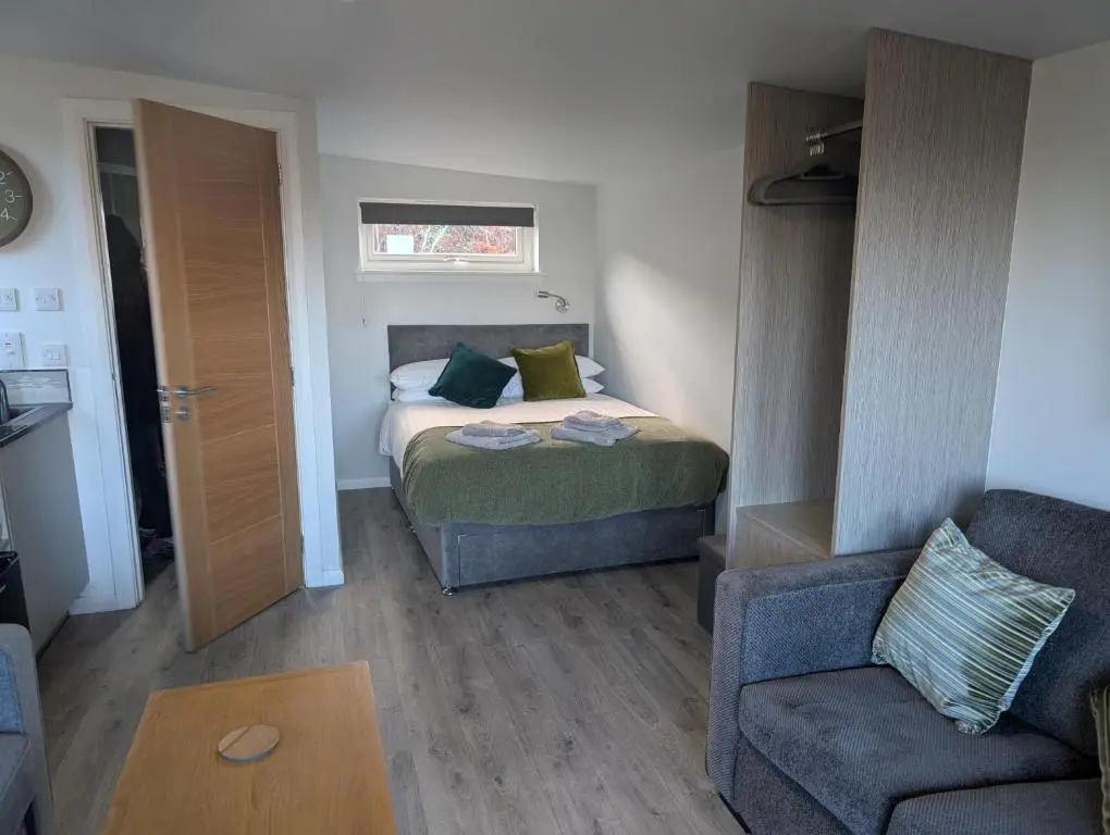 a bedroom with a bed and a couch and a chair at Inverness Ardtower Escapes in Culloden