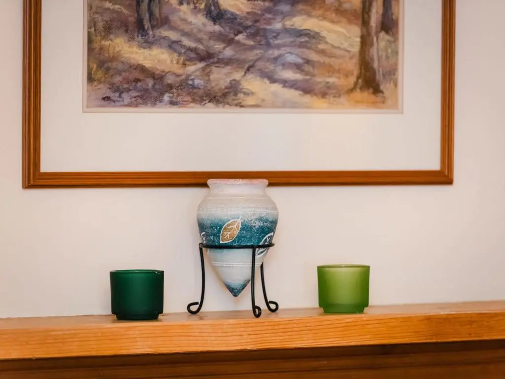 a vase sitting on a shelf with two green cups at Villa Netherwood by Interhome in Newtonmore