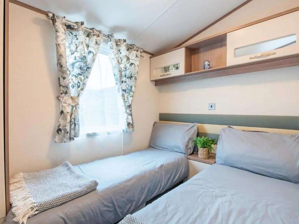 two beds in a small room with a window at Holiday Home ScottishHighlands-LochNess by Interhome in Fort Augustus