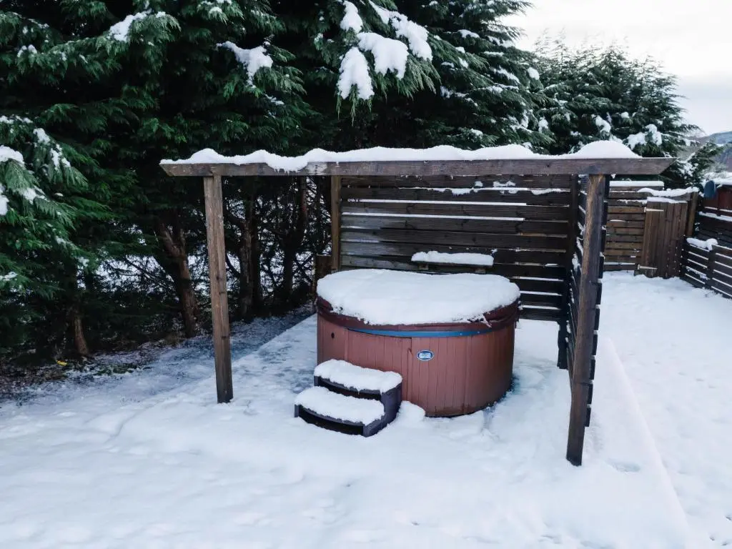 a snow covered hot tub and a gazebo at Holiday Home ScottishHighlands-LochNess by Interhome in Fort Augustus