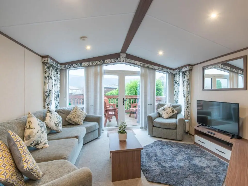 a living room with a couch and a television at Holiday Home ScottishHighlands-LochNess by Interhome in Fort Augustus