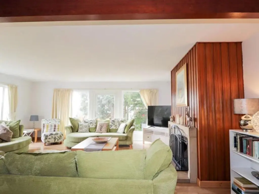 a living room with a green couch and a fireplace at Holiday Home Greenaway by Interhome in Skye of Curr