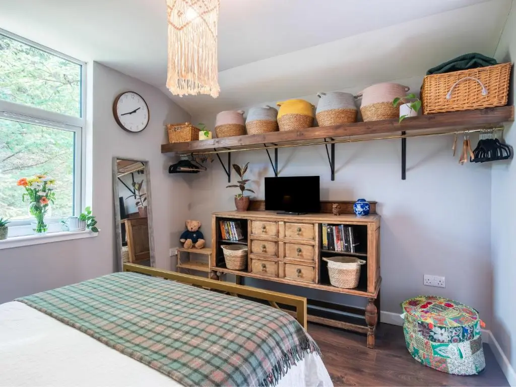 a bedroom with a bed and a tv on a shelf at Chalet The Cabin by Interhome in Eskadale