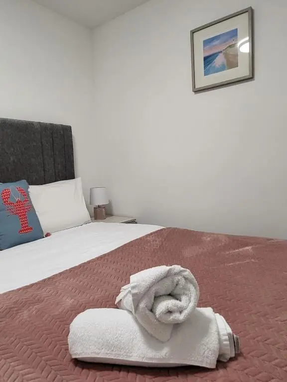 a bedroom with a bed with a towel on it at Harbour Nights Lossiemouth in Lossiemouth
