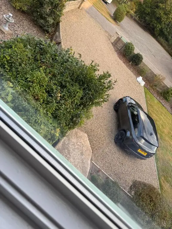 a car parked in a yard next to a bush at Woodlands Banff in Banff