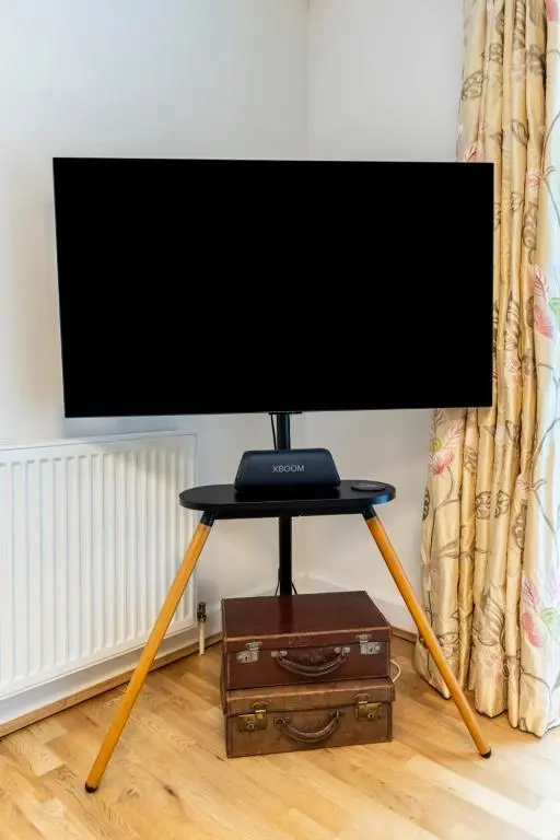 a flat screen tv on a stand in a room at Calder apartment Raven Wing in Fort Augustus