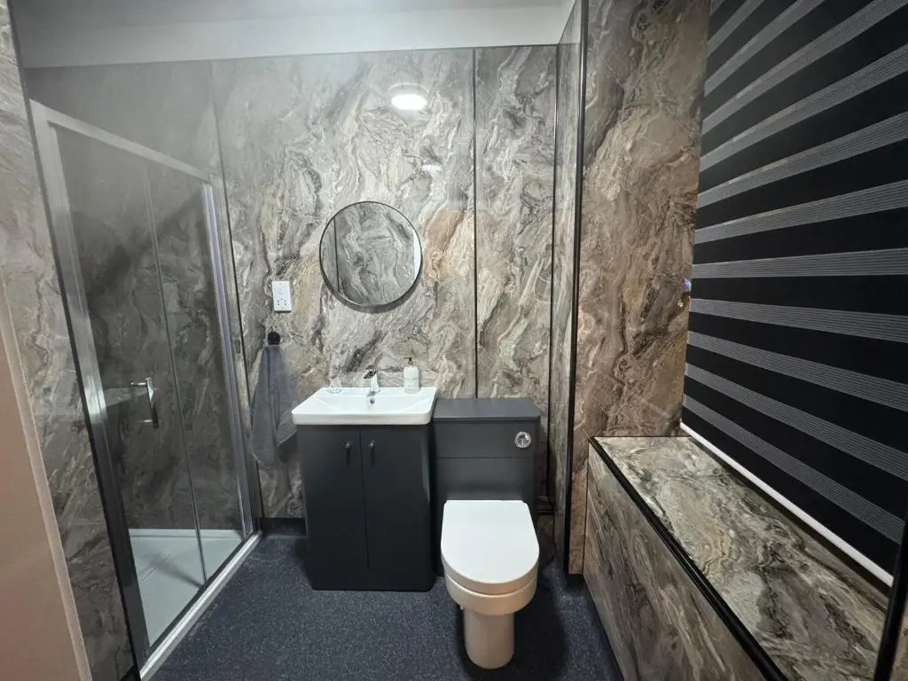 a bathroom with a shower and a toilet and a sink at TSB Rooms in Turriff