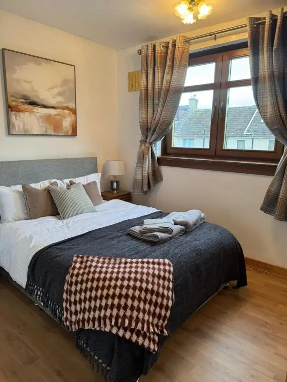 a bedroom with a large bed and a window at Aberdeen Home near City in Aberdeen