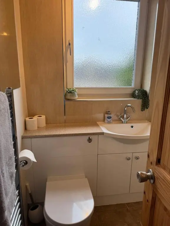 a bathroom with a toilet and a sink and a window at Aberdeen Home near City in Aberdeen